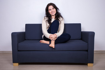 Fototapeta na wymiar young woman sitting on sofa at home