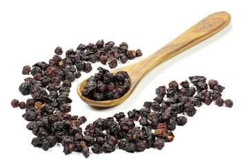 getrocknete Schisandrabeeren mit einem Löffel aus Olivenholz isoliert auf weißem Hintergrund