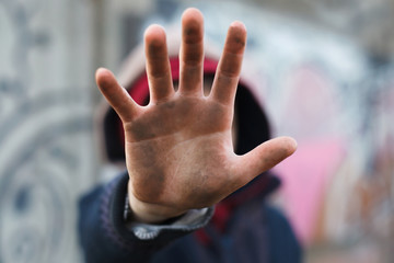 dramatic portrait of a little homeless boy, dirty hand