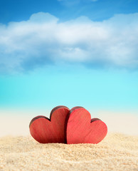Two wooden hearts on the summer beach