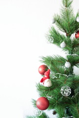 Christmas tree with ornaments on white wall background with space for text
