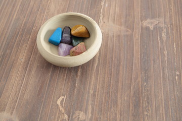 mineral colors on a clay bowl on a wooden table
