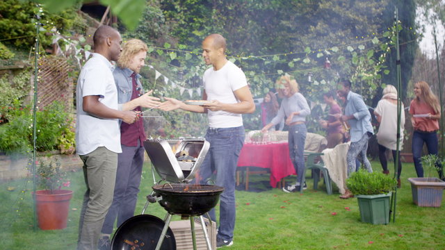  Happy mixed ethnicity group of friends chatting & having fun at bbq party