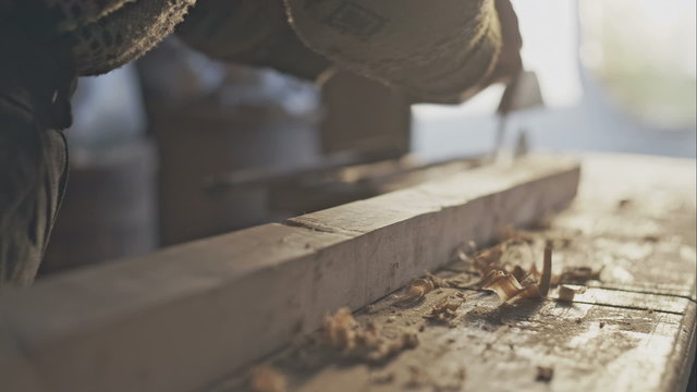 Hands of a carpenter planed wood, workplace