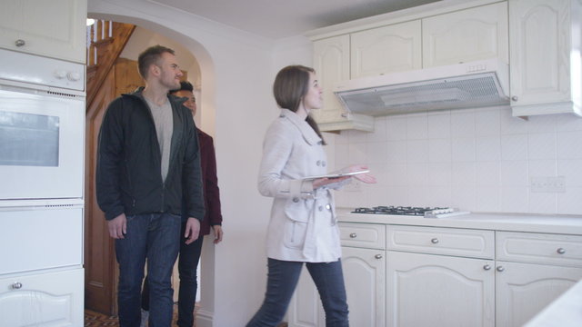  Young gay couple with real estate agent, looking at home to buy or rent