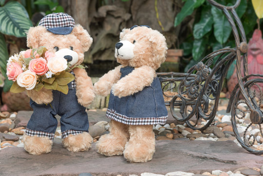 two teddy bears on garden background