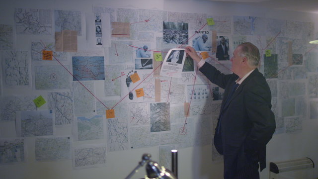  Police detective working alone in incident room to try and solve a case