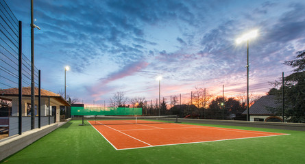 Tennis court at a private estate in the twilight and magic sky - obrazy, fototapety, plakaty