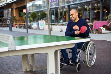 disabled man enjoying a game of ping pong in his wheelchair