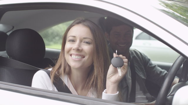  Portrait of attractive young woman with keys to her new car