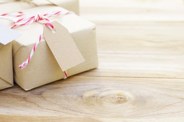 gift box with red strip ribbon and tag on wood table 