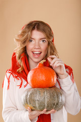 Girl with curly hair in a scarf. Girl holding pumpkin.