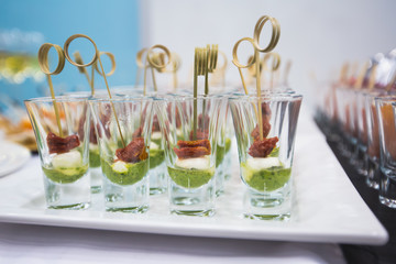 Beautifully decorated catering banquet prepared table with different food snacks and appetizers with sandwich, caviar, fresh fruits on corporate christmas birthday party event or wedding celebration 