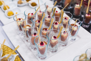 Beautifully decorated catering banquet prepared table with different food snacks and appetizers with sandwich, caviar, fresh fruits on corporate christmas birthday party event or wedding celebration 