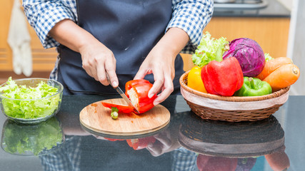 Female cook cutting bell pepper