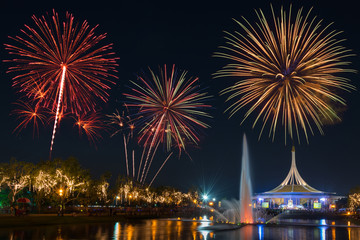 Naklejka premium Beautiful building in public park on night sky with fountain foreground and fireworks backgrond. Suanluang Rama 9, Thailand.