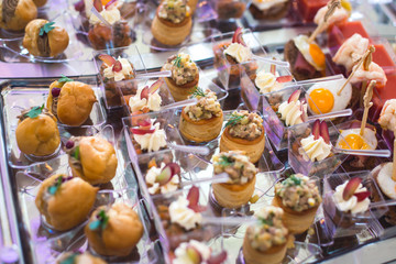 Beautifully decorated catering banquet table with different food snacks and appetizers with sandwich, caviar, fresh fruits on corporate christmas birthday party event or wedding celebration 