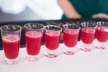 Beautiful row line of different colored alcohol cocktails with mint on a christmas party, martini, vodka with bubbles, wine and others on decorated catering bouquet table on open air event, picture 
