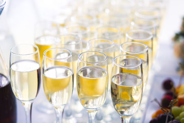 Beautiful row line of different colored alcohol cocktails with mint on a christmas party, martini, vodka with bubbles, wine and others on decorated catering bouquet table on open air event, picture 