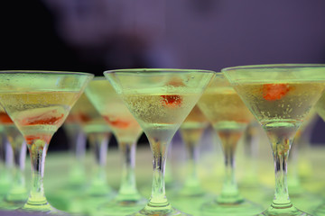 Beautiful row line of different colored alcohol cocktails with mint on a christmas party, martini, vodka with bubbles, wine and others on decorated catering bouquet table on open air event, picture 