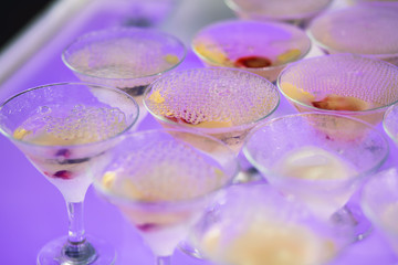 Beautiful row line of different colored alcohol cocktails with mint on a christmas party, martini, vodka with bubbles, wine and others on decorated catering bouquet table on open air event, picture 