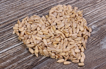 Heart of sunflower seeds on wooden background