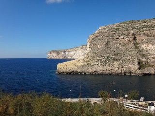 Скалы и набережная в морском заливе в солнечный день