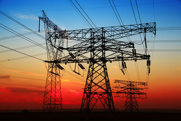 The silhouette of the evening electricity transmission pylon