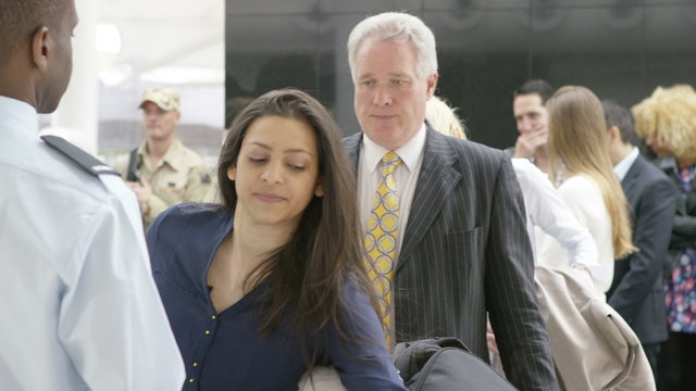  Airport security guards on duty, searching passengers before a flight