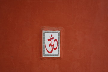 Terracotta wall with Hindu Om symbol, India