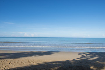 tropical beach with blue sky and calm blue sea surf