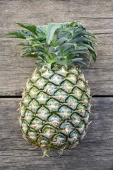 green sweet Pineapple on wood floor