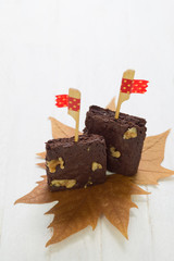 Decorated chocolate brownies with walnut  on white wood backgrou