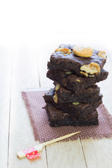 Decorated chocolate brownies with walnut  on white wood backgrou