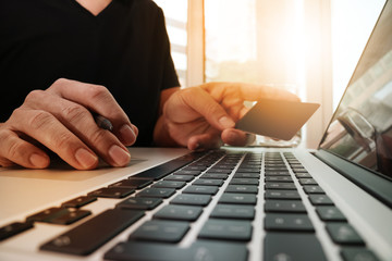 hands using laptop and holding credit card with "Secure payment"