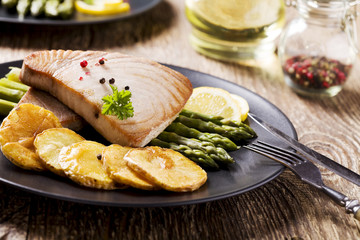 Grilled tuna steak served on asparagus with roasted potatoes.