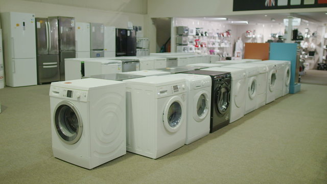 Interior view of white goods and electronics appliance store showroom. No people.