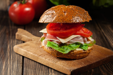 Delicious sandwich with prosciutto ham, cheese and vegetables