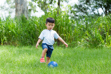 Little boy play soccer ball at park