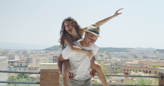  Happy attractive couple on vacation having fun outdoors in the sunshine. 