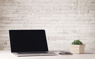 Business laptop with white brick wall