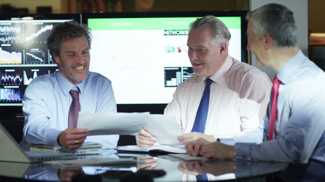  Mature male businessmen in a meeting analysing figures and statistics