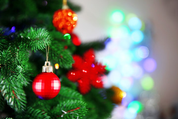 Christmas red bauble on a fir tree over blurred background