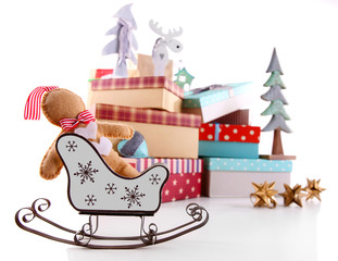 Naklejka premium Sledge on background of beautiful Christmas gifts with toys isolated on white
