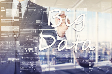 the businessman in the office is writing on the transparent board Big Data