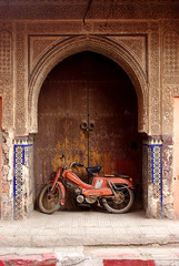 Naklejka na ściany i meble Old motorbike near the ancient Moroccan gate, Marrakesh