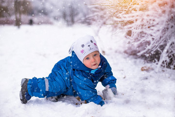 Fototapeta na wymiar Happy baby-boy having fun in winter park 