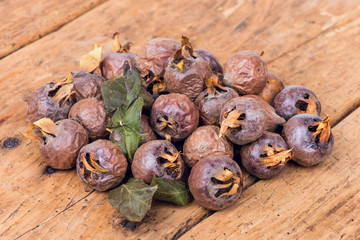 Healthy ripe Medlars on the old wooden table