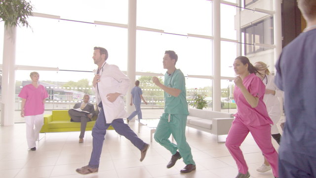  Medical Team Running Through Hospital Building, Responding To An Emergency