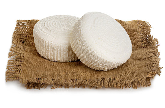 Traditional fresh cottage cheese on vintage burlap close-up on a white background.